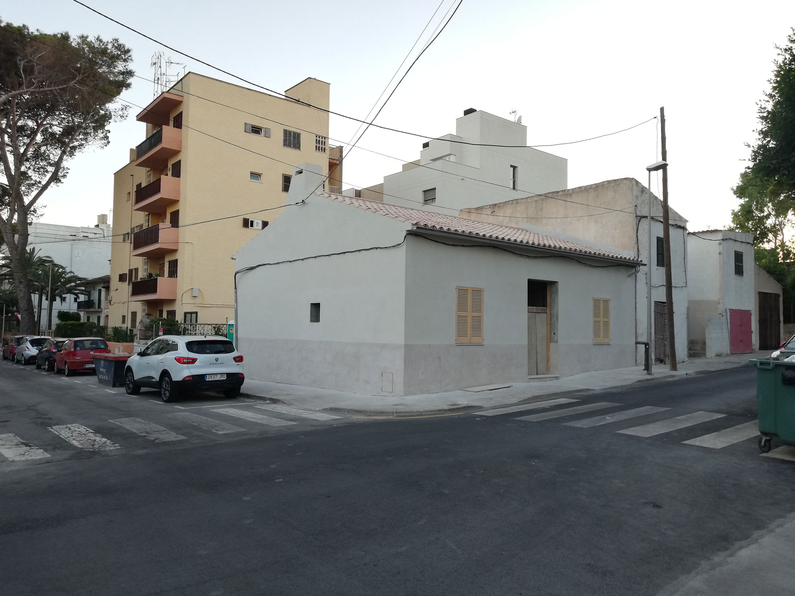vista exterior de una vivienda, se ve la carretera y coches aparcados